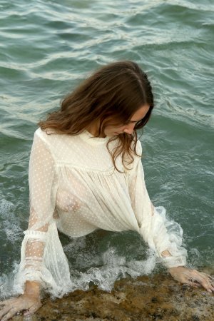 Danniela teases with sheer blouse, legs spread, then she spreads her bare pussy on the beach — Danniela #1