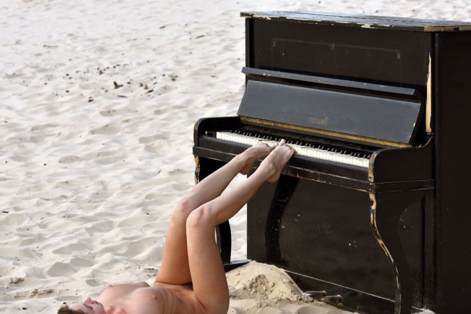 Noreen caresses herself naked on golden sands, legs spread, pussy glistening as she plays piano — Noreen #11